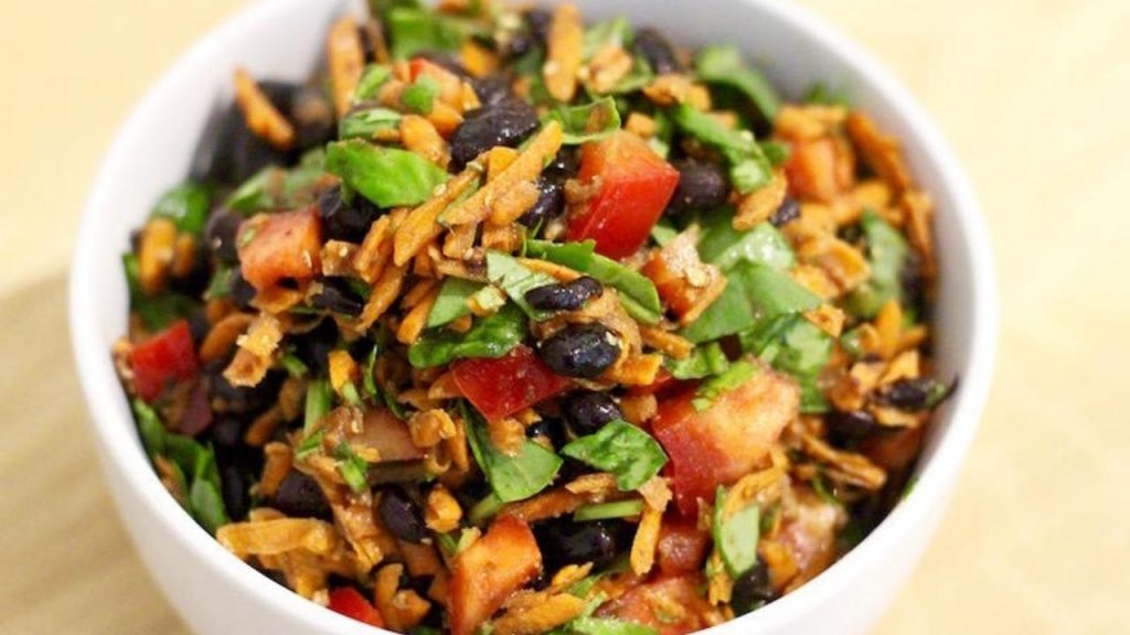 Black bean salad with shredded carrots in a white bowl