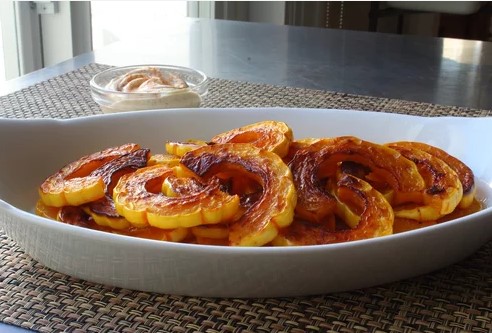 Roasted delicata squash in a white dish on a table