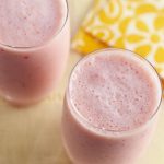 Two very berry smoothies with yellow napkin on a table