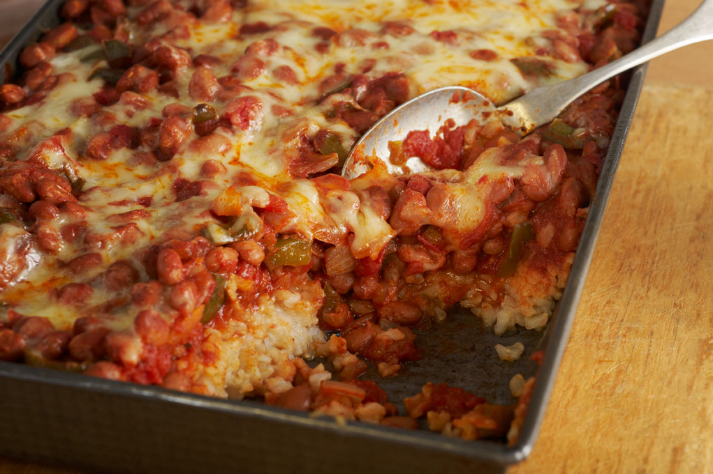 Bean and rice botana in a baking dish on a wooden table