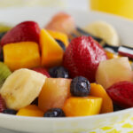 Fruit salad in white bowl on table