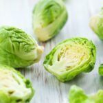 Brussel sprouts cut in half on a cutting board.