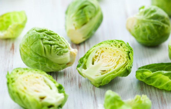 Brussel sprouts cut in half on a cutting board.