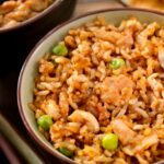 Chicken Fried Rice in a white and red bowl with chopsticks.