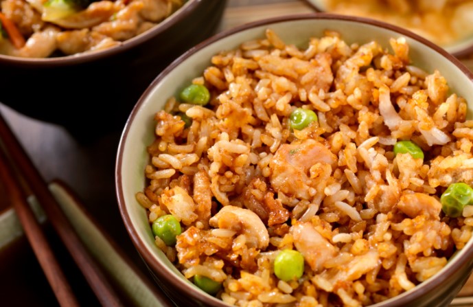 Chicken Fried Rice in a white and red bowl with chopsticks.