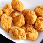 Chicken nuggets on a white serving dish.