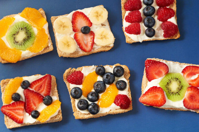 Fruit tarts placed on a solid blue tablecloth.