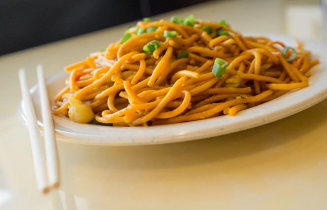 Lo mein on a white dish on top of a white table.