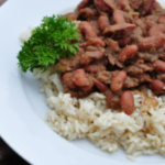 Louisiana Red Beans on top of rice on a white plate.