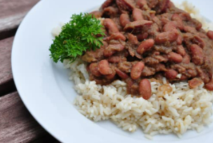 Louisiana Red Beans on top of rice on a white plate.