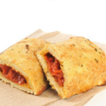 Mini calzones on a brown paper napkin with a white background.