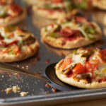 Mini pizzas on a baking sheet.