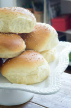 Mini sandwich rolls sit atop a white serving tray