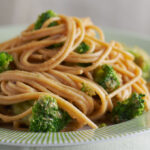 Noodles with Peanut Sauce and broccoli on white plate. Food styling by Catrine Kelty.