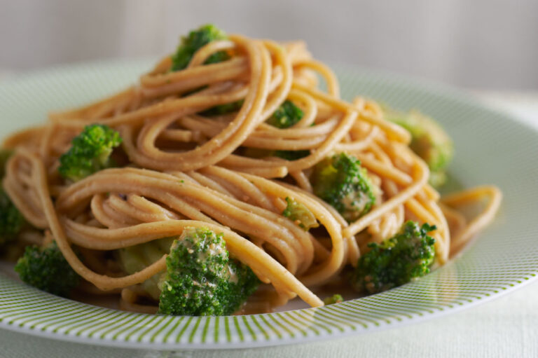 Noodles with Peanut Sauce and broccoli on white plate. Food styling by Catrine Kelty.