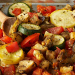 One serving dish of ratatouille with a wooden spoon.