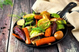 Roasted root vegetables in a black skillet.