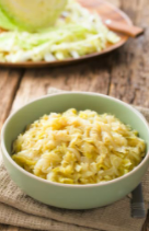 Sauteed cabbage in a pale green bowl.