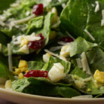 Spinach salad with eggs in a serving bowl.