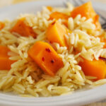 Squash and orzo on a white plate.
