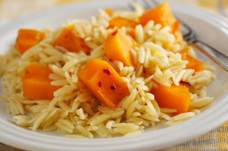 Squash and orzo on a white plate.