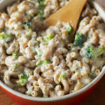 Macaroni and cheese in a bowl with a wooden spoon.