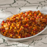 White dish with colorful sweet potato hash.