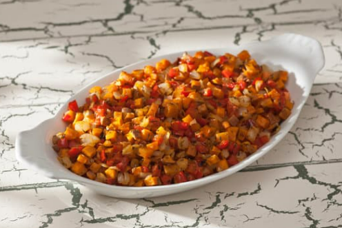 White dish with colorful sweet potato hash.