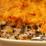 Closeup of sweet potato shepherds pie in a white baking dish