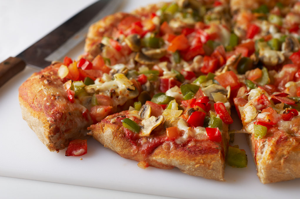 Closeup of The Works pizza topped with assorted vegetables