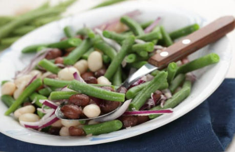 Three bean salad with green beans, kidney beans, and white beans on a white plate.