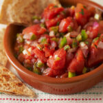 A small bowl of tomato salsa with tortilla chips