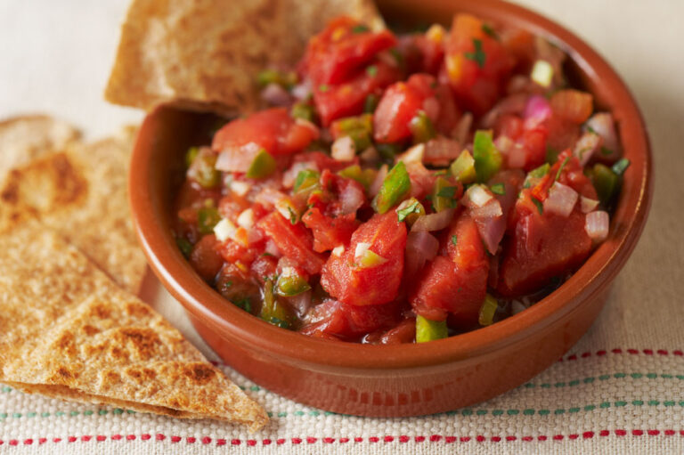 A small bowl of tomato salsa with tortilla chips