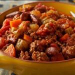 A yellow bowl full of turkey chili with vegetables