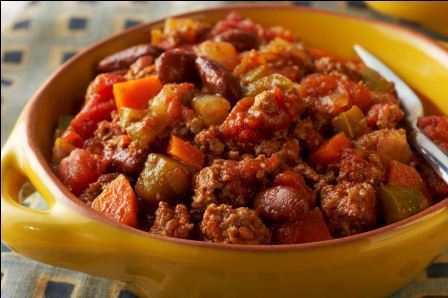 A yellow bowl full of turkey chili with vegetables