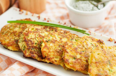 Zucchini patties on a long, rectangular white plate.