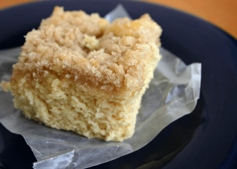 Square piece of coffee cake on top of a clear wrapper.