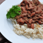 Louisiana Red Beans on top of rice on a white plate.