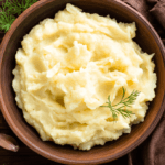 Mashed Potatoes in a wooden bowl with a dark background