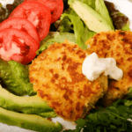 Salmon Cakes with dill sauce, avocado, tomatoes, and lettuce