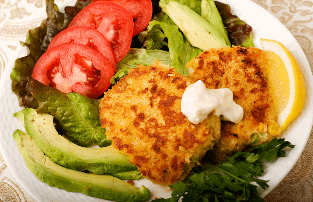 Salmon Cakes with dill sauce, avocado, tomatoes, and lettuce