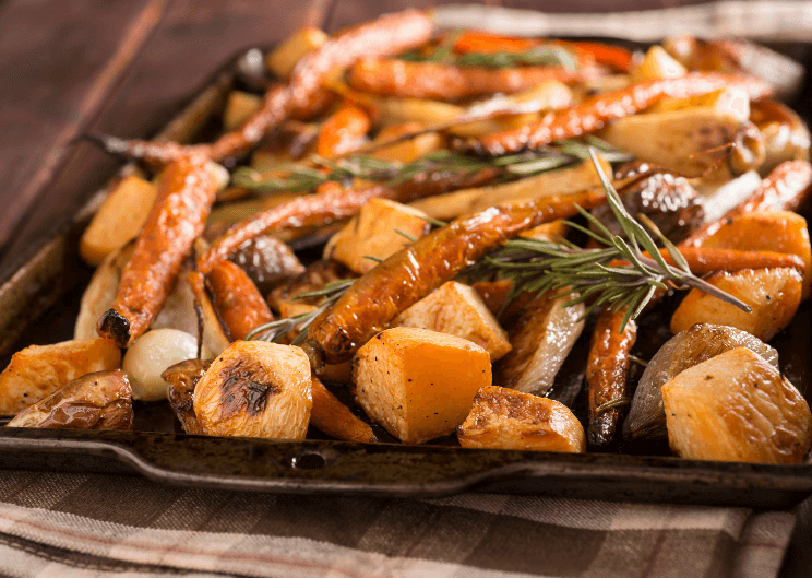 A baking sheet filled with different kinds of roasted root vegetables.
