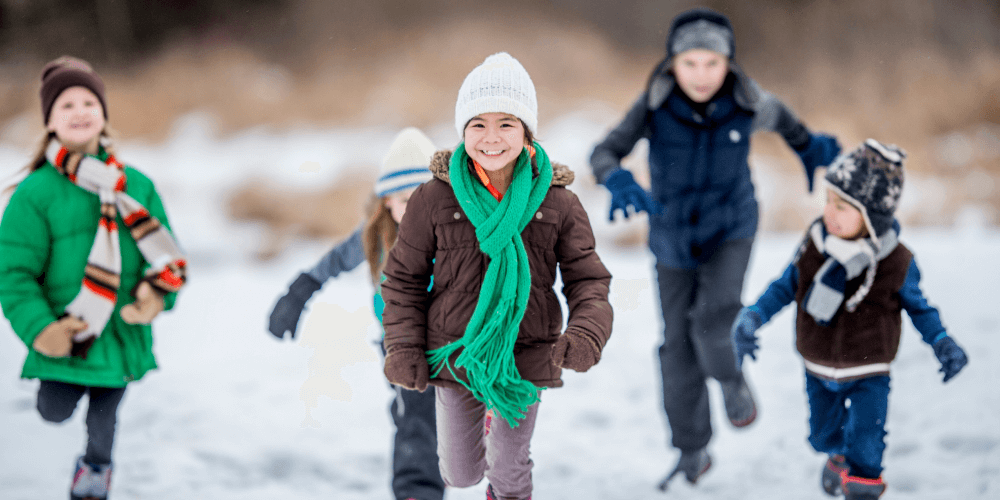 Staying active in the winter stock image of children running in the snow