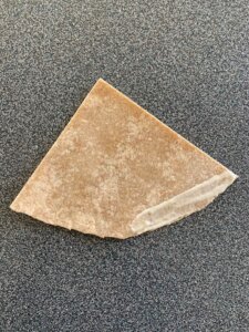 A triangle-shaped piece of dough used in a sambusa recipe