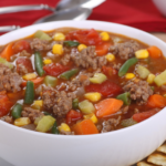 A large white bowl filled with beef and vegetable soup.