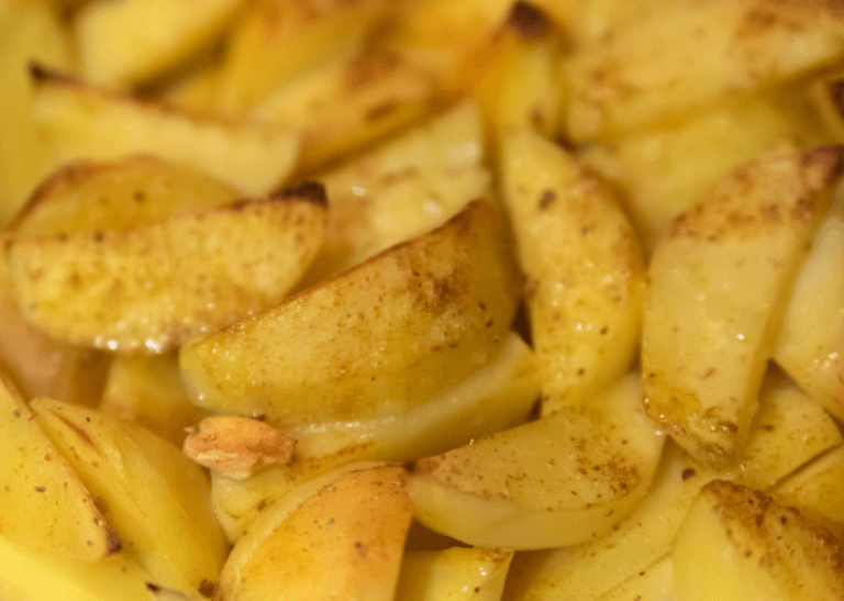 Sliced up cooked potatoes with spices.