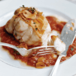 A plate of monkfish with tomato garlic sauce