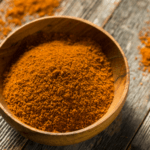 A wooden bowl with a mixture of spices for a seafood dry rub.