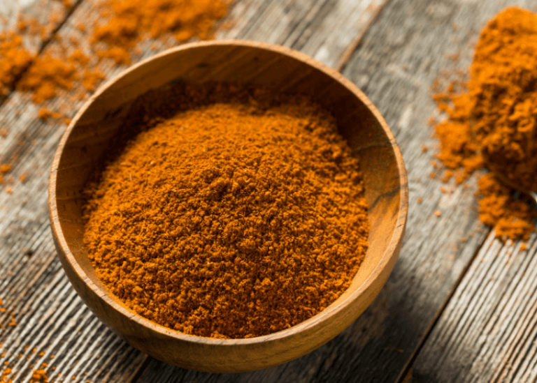 A wooden bowl with a mixture of spices for a seafood dry rub.