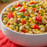 Succotash Salad with corn, diced tomatoes, beans in a large white bowl.